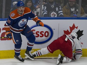 Edmonton Oilers Brandon Manning (26) flattens Winnipeg Jets Brandon Tanev (13) during first period NHL action on Monday, Dec. 31, 2018 in Edmonton.
(Greg Southam-Postmedia)
