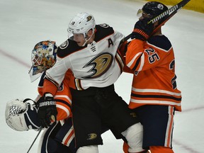 Edmonton Oilers defenceman Darnell Nurse (25) and goalie Cam Talbot (33) sandwich Anaheim Ducks Corey Perry between them during second period NHL action at Rogers Place in Edmonton, March 25, 2018.