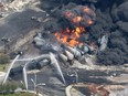 Smoke rises from railway cars that were carrying crude oil after derailing in downtown Lac-Megantic, Que., Saturday, July 6, 2013.