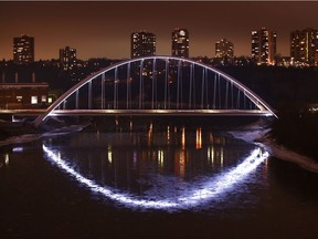 Walterdale Bridge lights reflected in the river and ice from the High Level Bridge in Edmonton, November 23, 2018.