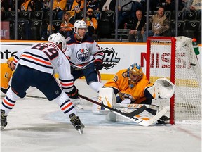 Goalie Pekka Rinne #35 of the Nashville Predators deflects a shot by Sam Gagner #89 of the Edmonton Oilers with Alex Chiasson looking on, during the second period at Bridgestone Arena on February 25, 2019 in Nashville, Tennessee.