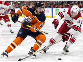 The Edmonton Oilers' Connor McDavid (97) battles the Carolina Hurricanes' Brett Pesce (22) during third period NHL action at Rogers Place, in Edmonton Sunday Jan. 20, 2019. The Hurricanes won 7-4.