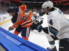 Edmonton Oilers' Ryan Nugent-Hopkins (93) battles San Jose Sharks' Brenden Dillon (4) during the first period of a NHL game at Rogers Place in Edmonton, on Saturday, Feb. 9, 2019.