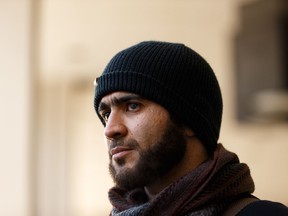 Omar Khadr listens as lawyer Nate Whitling speaks about his application to end his sentence outside of Court of Queen's Bench in Edmonton, on Tuesday, Feb. 26, 2019.