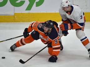 Edmonton Oilers Connor McDavid (97) gets tripped up by New York Islanders Adam Pelech (3) during NHL action at Rogers Place in Edmonton, February 21, 2019. Ed Kaiser/Postmedia