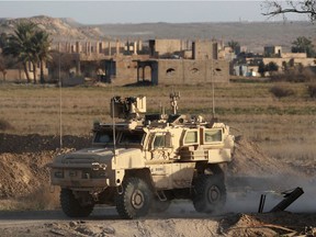 A US military vehicle drives through the Syrian village of Baghuz in the countryside of the eastern Deir Ezzor province on January 26, 2019. - The Syrian Democratic Forces (SDF), with backing from a US-led coalition, are battling to expel the last jihadists of the Islamic State group from hamlets in the eastern province of Deir Ezzor.