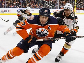 Anaheim Ducks' Rickard Rakell (67) and Edmonton Oilers' Milan Lucic (27) battle for the puck during second period NHL action in Edmonton, Alta., on Saturday February 23, 2019.