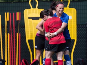 Canada goalkeeper Erin McLeod, back, jokes with Diana Matheson during a FIFA Women's World Cup soccer practice session in Vancouver, B.C., on June 24, 2015. Veterans Diana Matheson and Erin McLeod return to the Canadian lineup for the Algarve Cup starting Wednesday against Iceland.