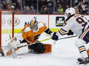 Philadelphia Flyers' Carter Hart, left, blocks a shot by Edmonton Oilers' Connor McDavid during the first period of an NHL hockey game, Saturday, Feb. 2, 2019, in Philadelphia.