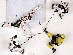 Edmonton Oilers goaltender Mikko Koskinen (19)  reaches to block a shot by Nashville Predators left wing Filip Forsberg (9) on Monday, Feb. 25, 2019, in Nashville, Tenn. Also defending for the Oilers are Andrej Sekera (2) and Oscar Klefbom (77).