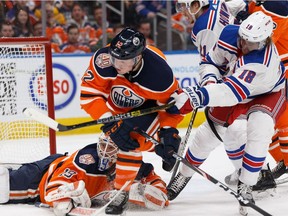 Edmonton Oilers' Colby Cave (12) battles New York Rangers' Marc Staal (18) during the second period at Rogers Place in Edmonton, on Monday, March 11, 2019.