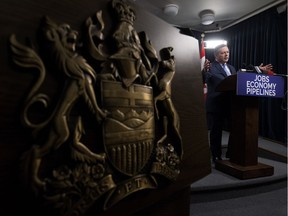 The Alberta coat of arms is visible in the foreground as UCP Leader Jason Kenney speaks to the media as he responds to the speech from the throne at the Alberta legislature in Edmonton on Monday, March 18, 2019.