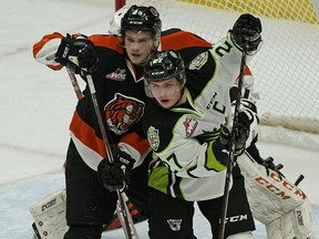 Edmonton Oil Kings captain Trey Fix-Wolansky (right) is checked by Medicine Hat Tigers Linus Nassen during WHL hockey game action at Rogers Place on Friday March 1, 2019.