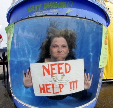 Alberta Employment and Immigration Area Manager Jane Chase post a help wanted poster from inside a dunk tank at the job fair held at Alberta Sevice Centre at 63 and Gateway Boulevard. Perry Mah/Postmedia