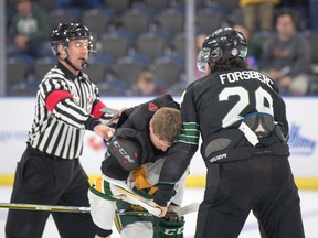 University of Alberta Golden Bears defenceman Sawyer Lange is forced to the ice and has his sweater taken off by University of Saskatchewan Huskies forward Alex Forsberg, who had just turned over the puck for an empty-net goal by Bears rookie Grayson Pawlenchuk on the way to a 3-0 win that sent Alberta to the final of the 2019 U-Sports men's hockey national championships in Lethbridge, Alberta. Lange ended up defending himself and because the two fought, which carries a one-game suspension, his status for the final was up in the air.