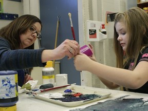 Tracy Hanson (left), an educational assistant at Virginia Park School, works with grade four student Shylo Thompson (right).