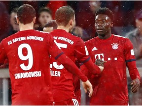 Bayern's Alphonso Davies, right, celebrates after scoring his side's sixth goal during the German Bundesliga soccer match between FC Bayern Munich and 1. FSV Mainz 05 in Munich, Germany, Sunday, March 17, 2019.