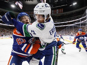 Vancouver Canucks' Loui Eriksson (21) is hit by Edmonton Oilers' Matthew Benning (83) during first period NHL action in Edmonton, Alta., on Thursday March 7, 2019.