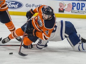 Kris Russell (No. 4) of the Edmonton Oilers, clears the puck in front of the net and away from Tyler Ennis (No. 63) of the Toronto Maple Leafs at Rogers Place in Edmonton on March 9, 2018.