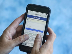 In this Aug. 21, 2018, file photo a Facebook start page is shown on a smartphone in Surfside, Fla.