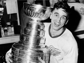 In this April 16, 1954, file photo, Detroit Red Wings captain Ted Lindsay hugs the Stanley Cup after his team defeated the Montreal Canadiens 4-3, in a sudden death extra period to win the Stanley Cup.