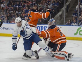 Darnell Nurse (25) and goalie Anthony Stolarz (32) of the Edmonton Oilers, push John Tavares (91)of the Toronto Maple Leafs at Rogers Place in Edmonton on March 9, 2018. Shaughn Butts / Postmedia