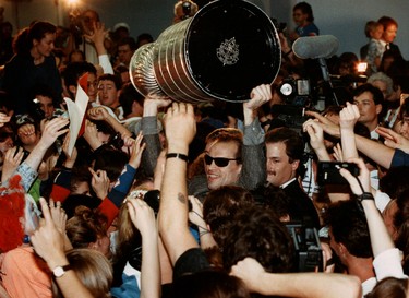 May 25, 1990. Edmonton Oilers captain Mark Messier makes his way through a crush of fans as he carries the Stanley Cup through the Edmonton International Airport after arriving from Boston. On May 24 1990 the Oilers won their fifth NHL Stanley Cup championship by beating the Boston Bruins in five games. Perry Mah/Edmonton Sun/Postmedia Network