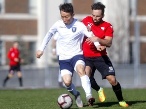 FC Edmonton midfielder Son Young-Chan, left, battles with a Cavalry FC midfielder Sergio Camargo during a friendly preseason training match at the Cohos Commons Field, Southern Alberta Institute of Technology (SAIT), in Calgary on Saturday, March 30, 2019.