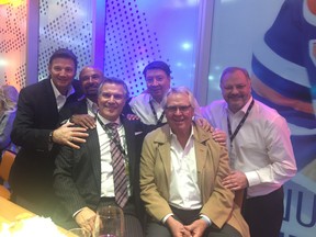 Clothier Sam Abouhassan and former Edmonton Oiler's legendary coach Glen Sather (front row l to r) celebrate in the teams Rogers Place dressing room, with (back row l to r) Mike Krushelnyski; Grant Fuhr; Jari Kurri  and Esa Tikkanen, the Oilers being named The Greatest NHL Team in 100 Years.