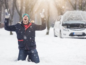 Young man on his knees on snowy road.