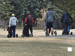 A group of golfers walking up hole #1 fairway after teeing off at Mill Woods Golf Club which is now open for the season in east Edmonton, April 11, 2019.