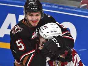 Edmonton Oil Kings Jake Neighbours (21) gets grabbed around the neck by Calgary Hitmen Jackson van de Leest (5) during WHL second round playoff action at Rogers Place in Edmonton, April 6, 2019.