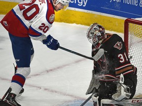 Edmonton Oil Kings David Kope (20) tries to flip the puck past Calgary Hitmen goalie Jack McNaughton (31) during WHL second round playoff action at Rogers Place in Edmonton, April 7, 2019.