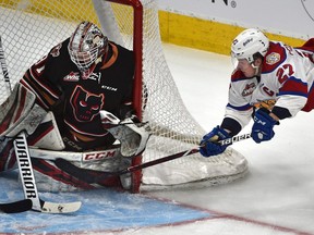 Edmonton Oil Kings Trey Fix-Wolansky (27) tries a mid-air wrap around on Calgary Hitmen goalie Jack McNaughton (31) during WHL secon dround playoff action at Rogers Place in Edmonton, April 6, 2019.