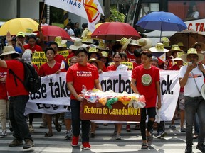 Environmentalists march outside the Canadian Embassy to demand the Canadian government to speed up the removal of several containers of garbage that were shipped to the country Tuesday, May 21, 2019, in Manila, Philippines.