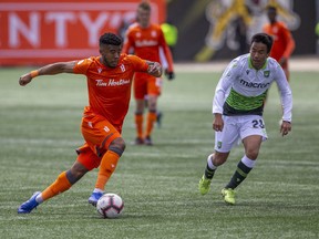 Forge FC's Emery Welshman, left, carries the ball past York 9 midfielder Wataru Murofushi during the inaugural soccer match of the Canadian Premier League between Forge FC of Hamilton and York 9 in Hamilton, Ont., on April 27, 2019.