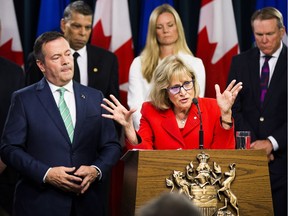 Premier Jason Kenney, left, listens to Janice MacKinnon, chair of a blue-ribbon panel announced to examine the Alberta government's financial situation on Tuesday.