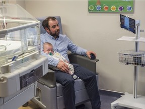 James Lane sits with his son Lorcan on Wednesday, May 1, 2019, at the Misericordia Community Hospital neonatal intensive care unit (NICU) while communicating with his wife on an iPad.