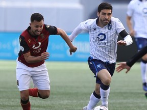 FC Edmonton midfielder Ramon Soria, right, dribbles away from a member of Valour FC at Investors Group Field in Winnipeg on Saturday May 4, 2019.