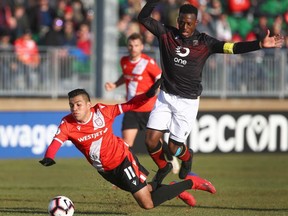 Cavalry FC Jose Escalante, left, is brought down by Valour FC Jordan Murrell during Canadian Premier League soccer action  between Cavalry FC and Valour FC at Atco Field in Spruce Meadows in Calgary on Wednesday, May 8, 2019.