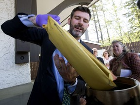 Mayor Don Iveson removes times from a 1967 time capsule at Fort Edmonton Park, in Edmonton Wednesday May 22, 2019. The time capsule was closed at the base of the Fort Edmonton Park flag pole in July 1967.