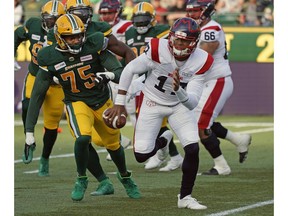 Montreal Alouettes quarterback Antonio Pipkin, right, runs with the ball with Edmonton Eskimos defensive lineman Nick Usher, left, on his heels during CFL action in Edmonton on June 14, 2019.