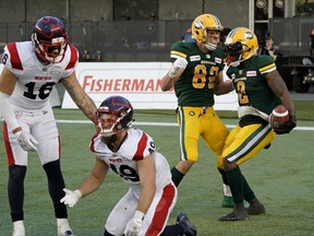 Edmonton Eskimos running back C.J. Gable (right) celebrates his touchdown with teammate Greg Ellingson against the Montreal Alouettes at Commonwealth Stadium in Edmonton on Friday, June 14, 2019. Alouettes Taylor Loffler (left) and Jean-Gabriel Poulin are in the foreground.