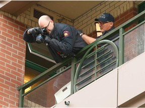 Calgary Police Forensics Unit members investigate outside an apartment building balcony at Riverfront Ave and 1 St SE in downtown Calgary on Wednesday, June 19, 2019. Accordiing to Police, a woman went over a 5th floor balcony railing as police executed a high-risk search warrant. She later died from injuries. ASIRT and Calgary Police continue to investigate.