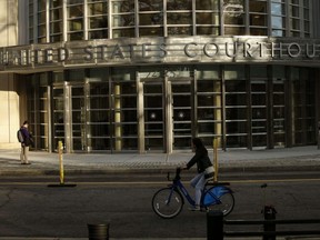 A woman bikes by the Federal District Court in Brooklyn, N.Y., on Dec. 15, 2015.