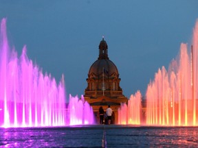 A couple walks towards the Alberta Legislature Building in the middle of the new water fountains near the Federal Building. The water feature changes colour. Hugo Sanchez/Special to the Edmonton Sun