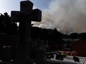Smoke billows near a cemetery as a wildfire rages in the outskirts of Cenicientos in central Spain on June 29, 2019. - Spain was hit by more wildfires as temperatures remained sky-high in the Europe-wide heatwave, authorities said, just as firefighters finally managed to contain another blaze they had been tackling for nearly 72 hours. (PIERRE-PHILIPPE MARCOU/Getty Images)