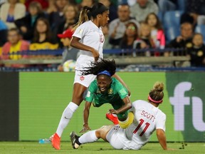 Gabrielle Aboudi Onguene of Cameroon, centre, is challenged by Ashley Lawrence, left, and Desiree Scott of Canada during the 2019 FIFA Women's World Cup France group E match between Canada and Cameroon at Stade de la Mosson on June 10, 2019 in Montpellier, France.