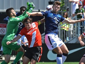 After FC Edmonton Amer Didic (R) and Cavalry FC Mason Trafford (5) went up for the header, goalkeeper Marco Carducci (1) punched the ball away during Canadian Premier League action at Clarke Stadium in Edmonton on Saturday, June 15, 2019.