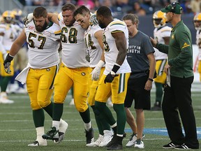 Edmonton Eskimos offensive lineman Jean-Simon Roy (68) is helped off the field against the Winnipeg Blue Bombers in Winnipeg on August 17, 2017.